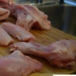 A cutting board with chicken pieces on it.