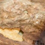 A piece of bread is sitting on top of a wooden table.
