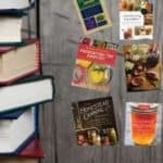 A stack of books on a wooden table.