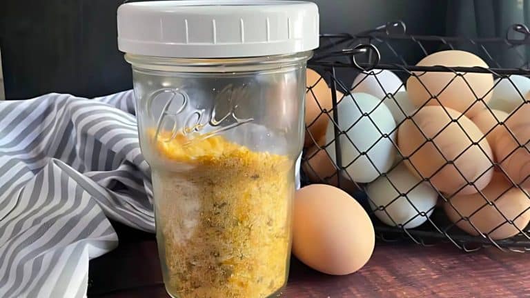 A glass jar with a white lid contains a yellow powdered mixture. Next to it, a wire basket holds various colored eggs. A striped cloth is draped to the side.