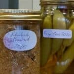Two jars of pickles with labels on them.