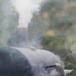A black grill with smoke coming out of it.