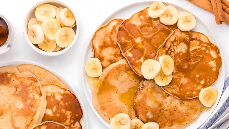A plate of pancakes topped with syrup and banana slices, accompanied by a bowl of additional banana slices.
