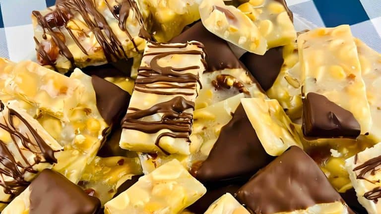 A close-up of assorted chocolate and nut bars, some drizzled with dark chocolate, on a checkered surface.