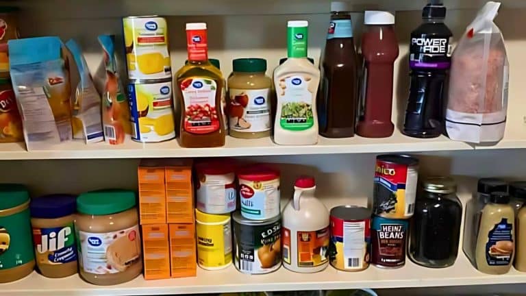 A pantry shelf stocked with various food items and condiments, including jars, bottles, and boxes of packaged goods.
