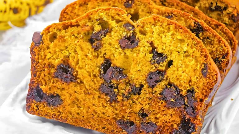 Sliced pumpkin bread with chocolate chips on a white surface.