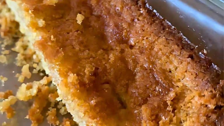 Close-up of a golden-brown pie crust in a glass dish, with a textured and crumbly surface.