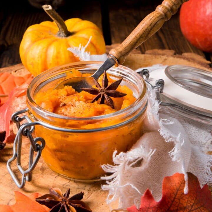 Pumpkin puree in a jar on a wooden table.