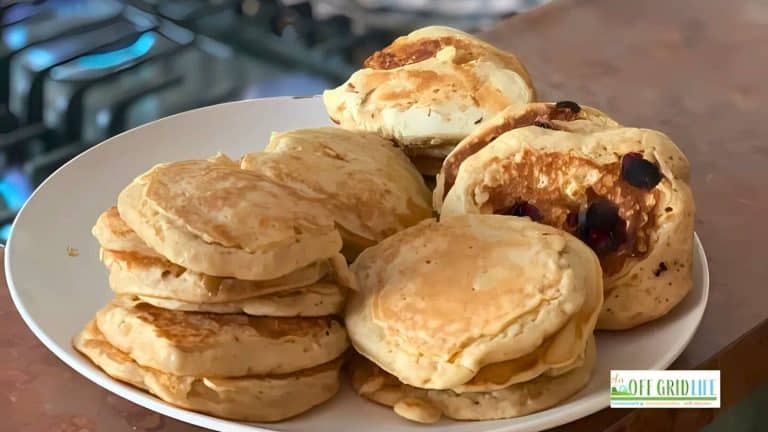 A plate filled with stacks of fluffy pancakes, with some pancakes having berries on top.