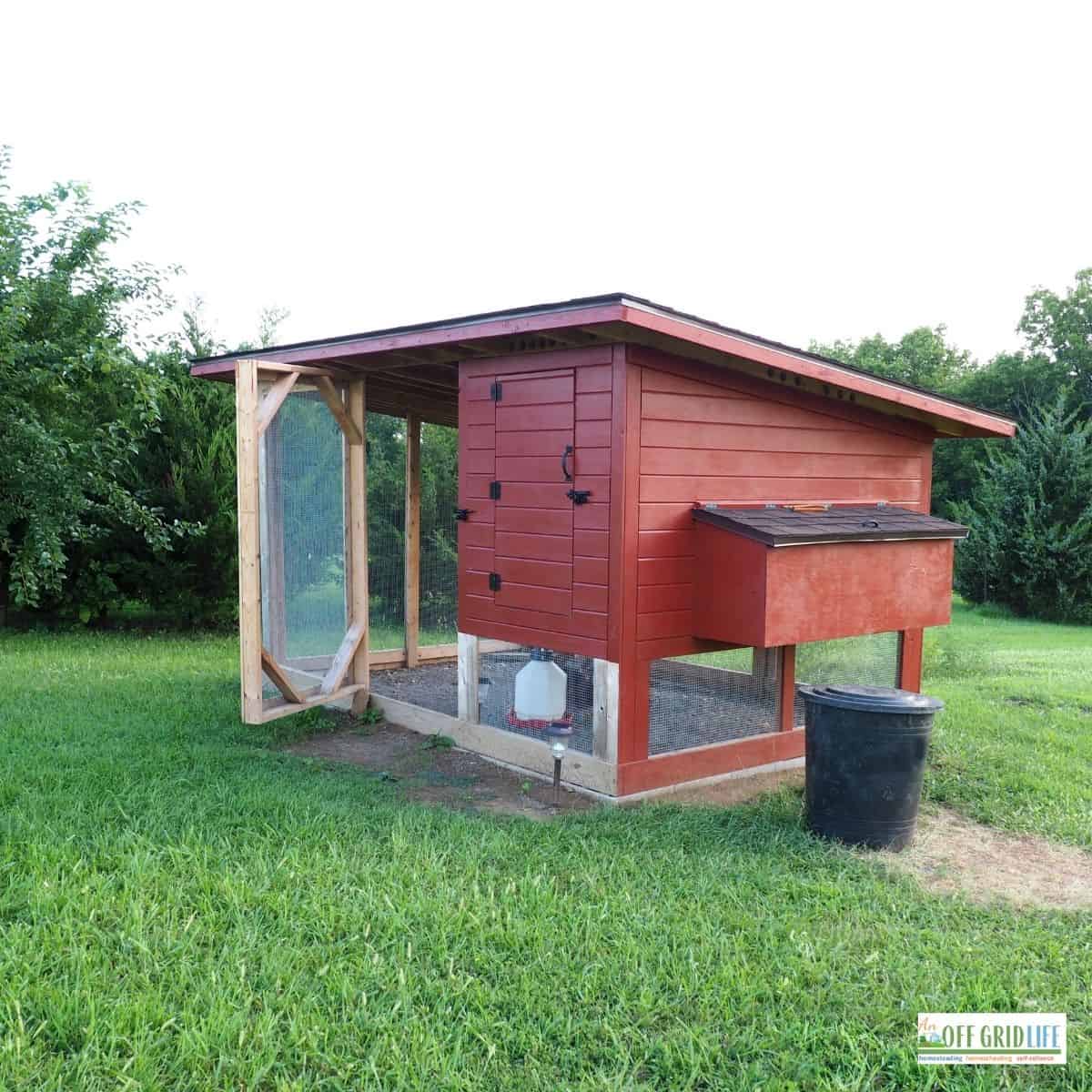 a raised red diy chicken coop with attached chicken run