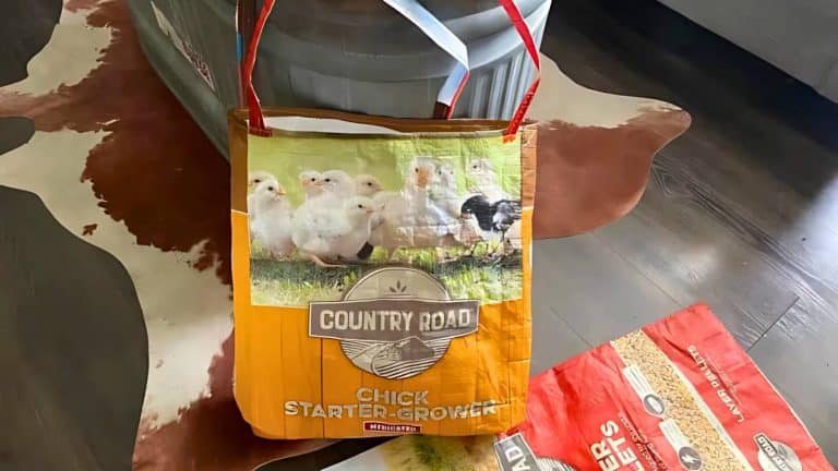 A tote bag made from a repurposed feed bag, featuring an image of chicks and the text "Country Road Chick Starter Grower.