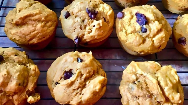 A batch of freshly baked muffins with chocolate chips cooling on a wire rack.
