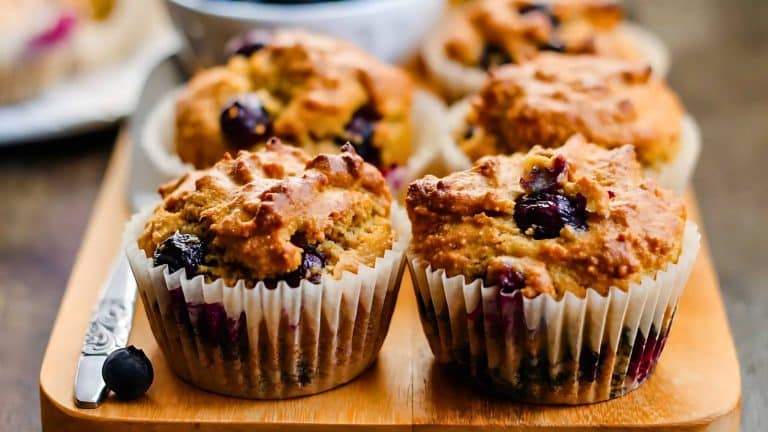 Blueberry muffins arranged on a wooden tray.