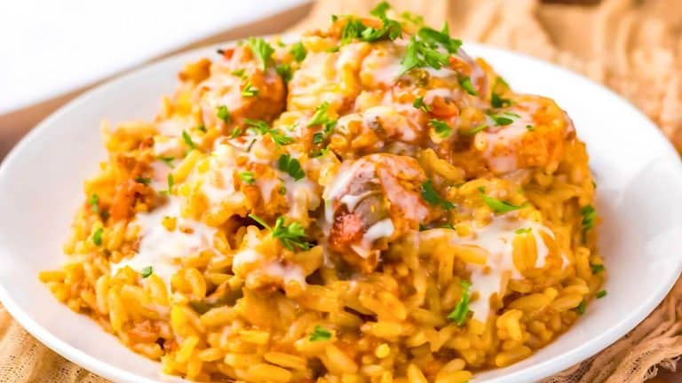 A plate of creamy risotto topped with parsley and chunks of meat, served on a white dish.