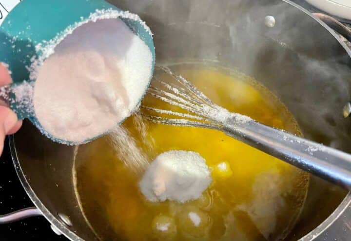 Adding sugar to dandelion jelly recipe.