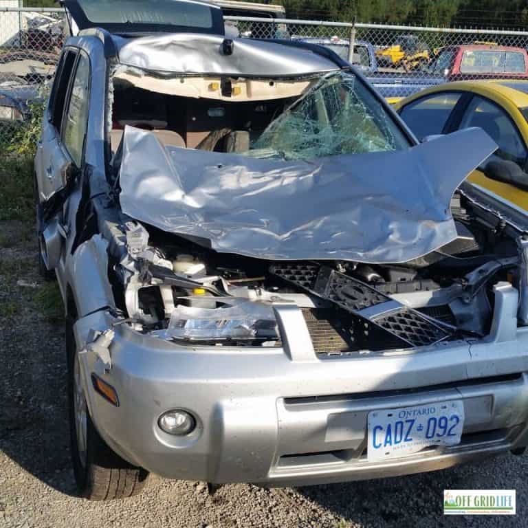 a picture of a silver suv with the front end crushed after an accident with a moose