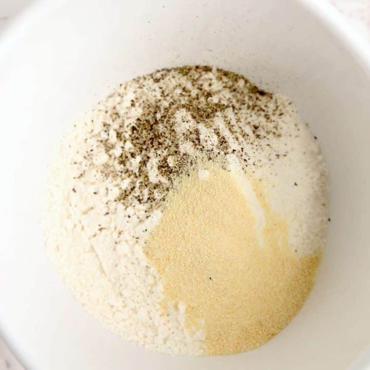 A white bowl with flour and spices in it.