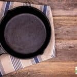 a picture of a single cast iron skillet on a blue and white wash cloth