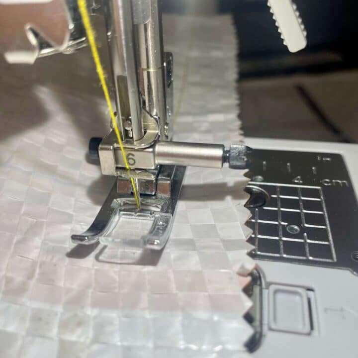 A sewing machine is being used to sew a piece of fabric.