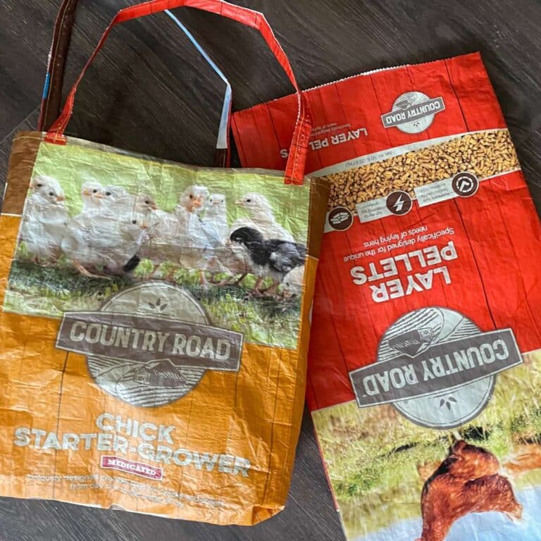 Two bags of chicken feed on a wooden floor.