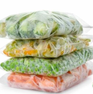 four stacks of ziploc bags filled with frozen vegetables