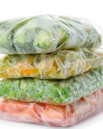 four stacks of ziploc bags filled with frozen vegetables