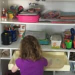 Child at homeschool shelving unit