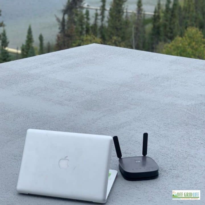 a laptop and router on a roof of an off grid cabin