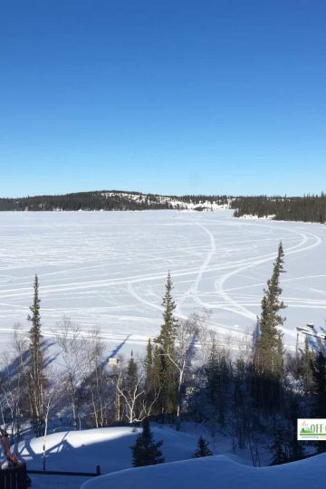 Living off the grid in winter view of lake covered in snow and ice.