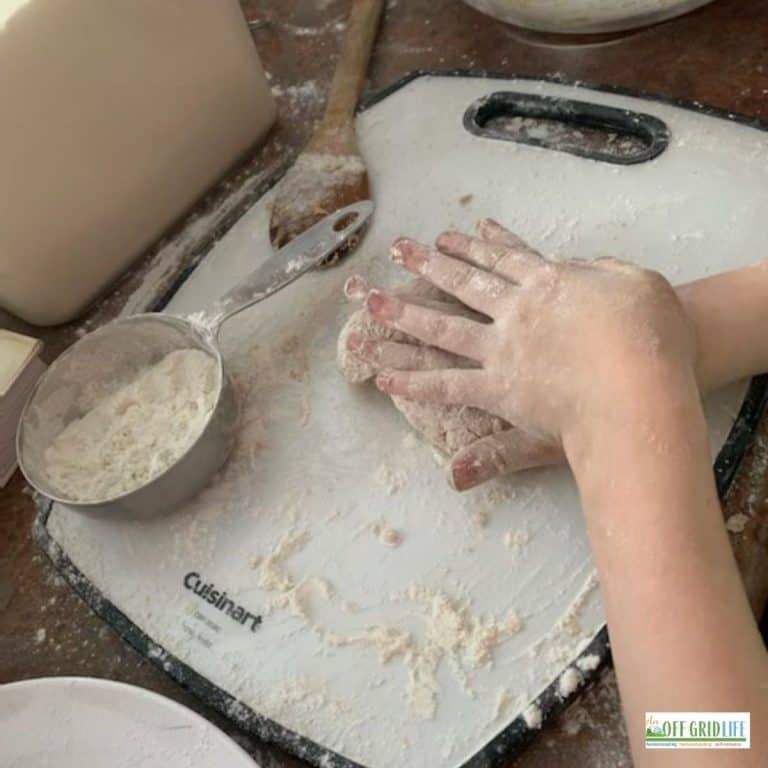 a person kneading hardtack dough on a cutting board