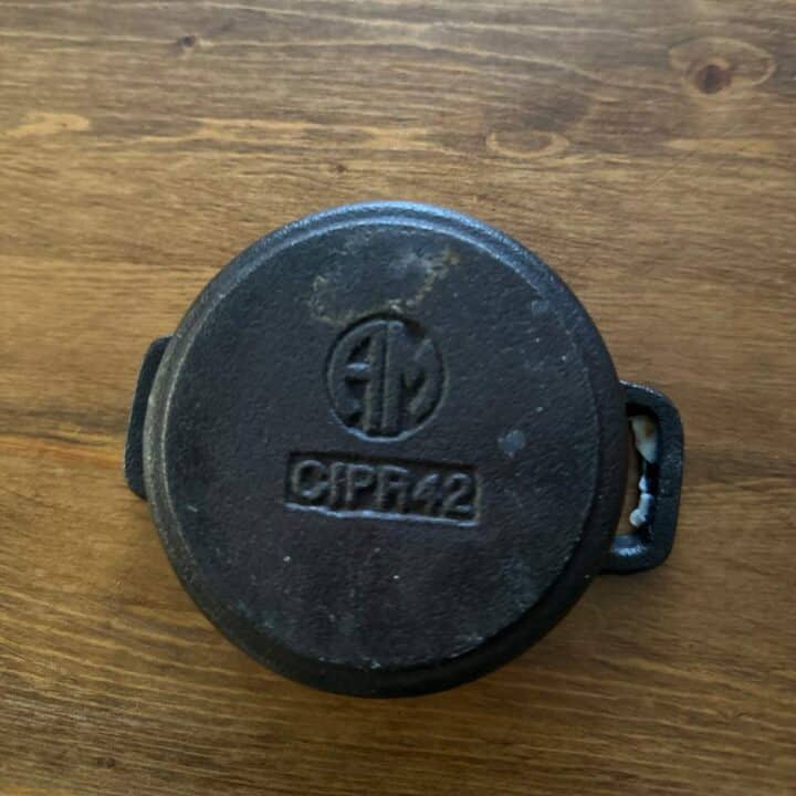 The bottom of a cast iron post with a logo and number.
