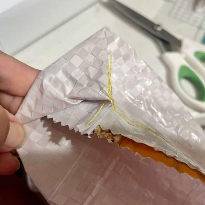 A person cutting a piece of paper with scissors.