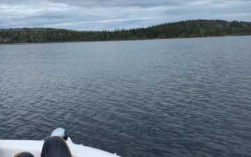 a picture off grid of someones feet up on a boat looking at open water.