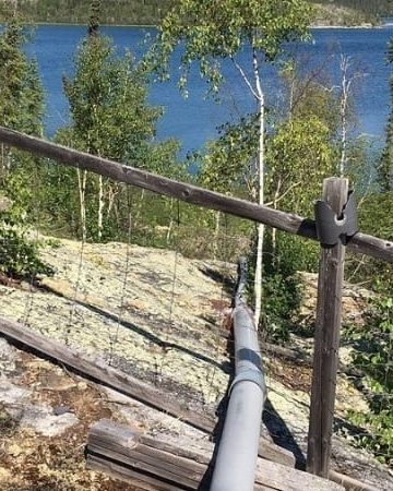 Our diy off grid water supply system above ground pipe going over rock down to the lake