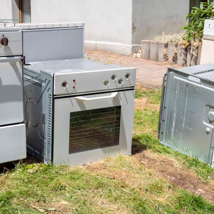 A stove and oven sitting in the grass.