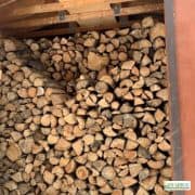 a large stack of split and dried wood in an off grid wood shack