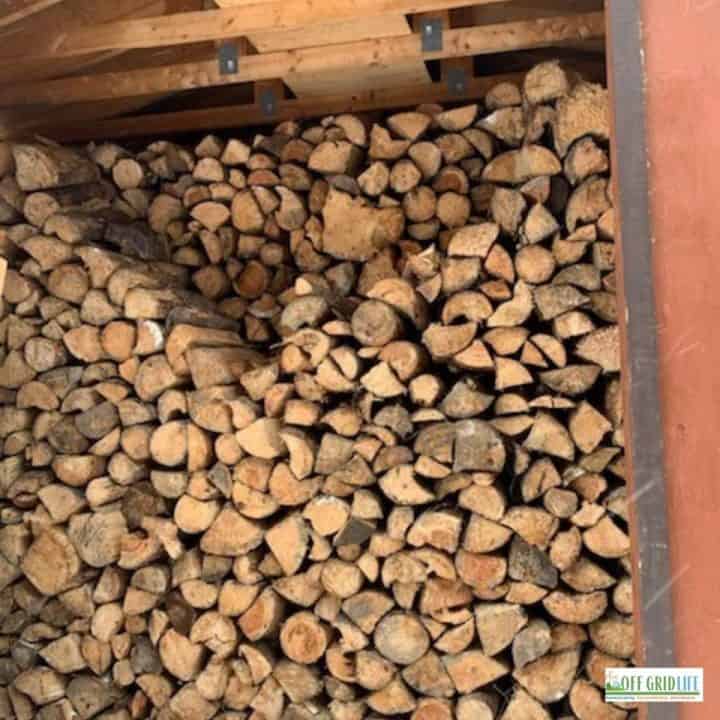 a large stack of split and dried wood in an off grid wood shack