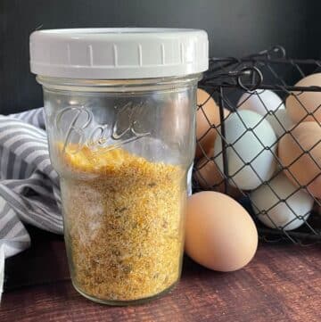 Dehydrated eggs in jar with basket of fresh eggs behind.