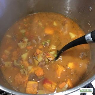 a stainless steel pot filled with ptarmigan spruce grouse stew