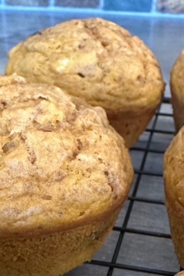 Freshly baked pumpkin chocolate chip muffins cooling on a wire rack.