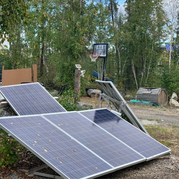 A basketball hoop with solar panels beside it.