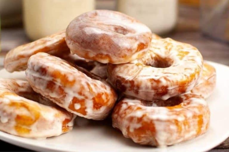 A plate of sourdough donuts is artfully stacked, each glazed to perfection.
