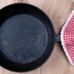 A small cast iron skillet with a red and white washcloth