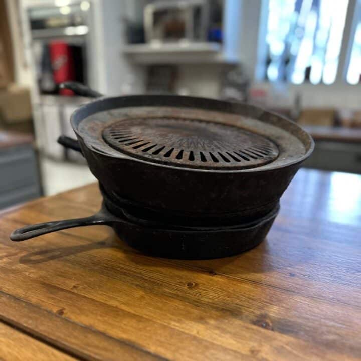 Two cast iron skillets sitting on top of a wooden table.