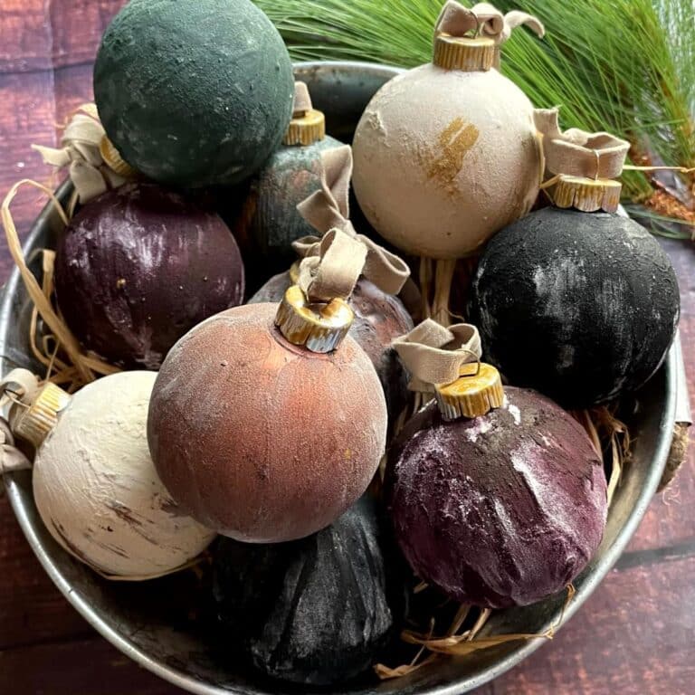 Vintage Christmas ornaments in a metal bowl with pine cones.