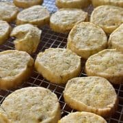Freshly baked round cookies cooling on a wire rack.