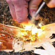 A person is cutting a piece of wood with a spark.