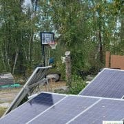 Solar panels in a backyard with a basketball hoop.