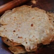 Sourdough Discard Tortillas on counter with wooden rolling pin.
