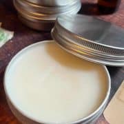 A tin of beeswax on a wooden table.